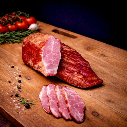 Smoked beef rib cuts on a wooden board, partially sliced to show juicy texture and marbling