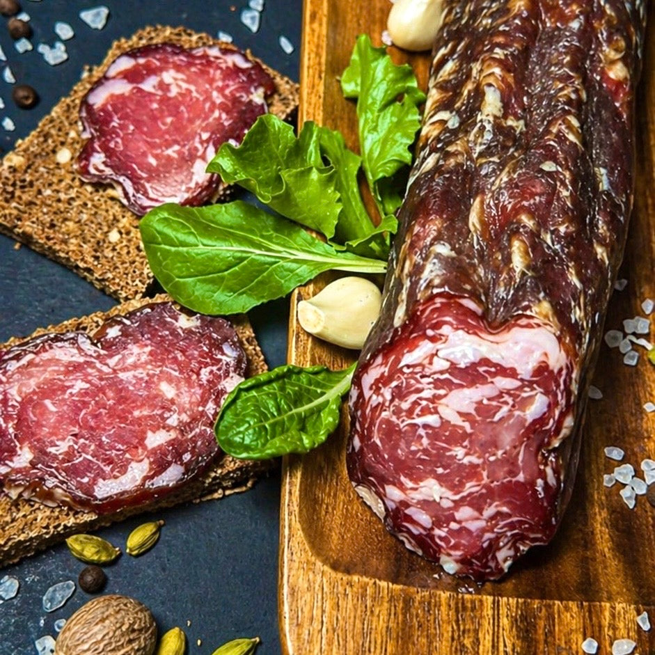 Coarse dry cured pork sausage sliced on wooden board
