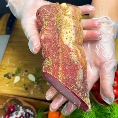 Freshly sliced Polandvica dry-cured pork loin on rustic board – Ukrainian Smokehouse