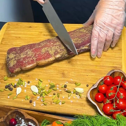 Polandvica dry-cured pork loin being sliced on wooden board – Ukrainian Smokehouse